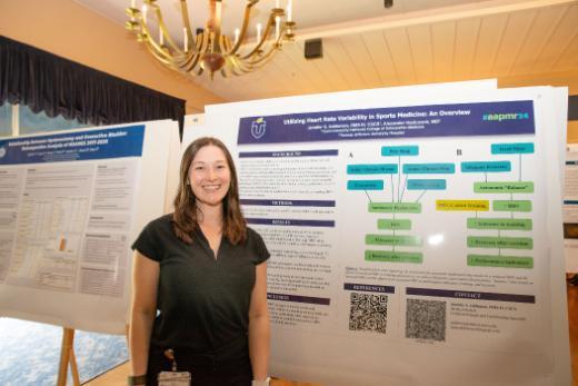 Student doctor Jennifer Addleman stands in front of her research poster titled 