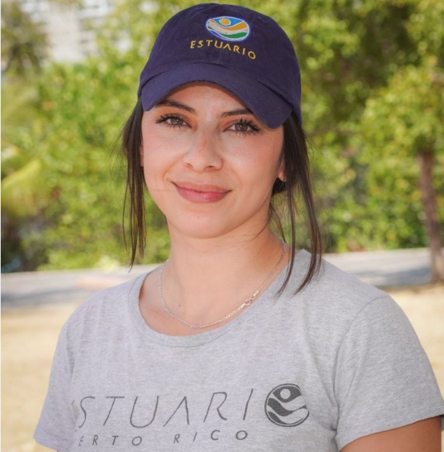 Delia Jimenez wearing a t-shirt and baseball cap that say "Estuario"