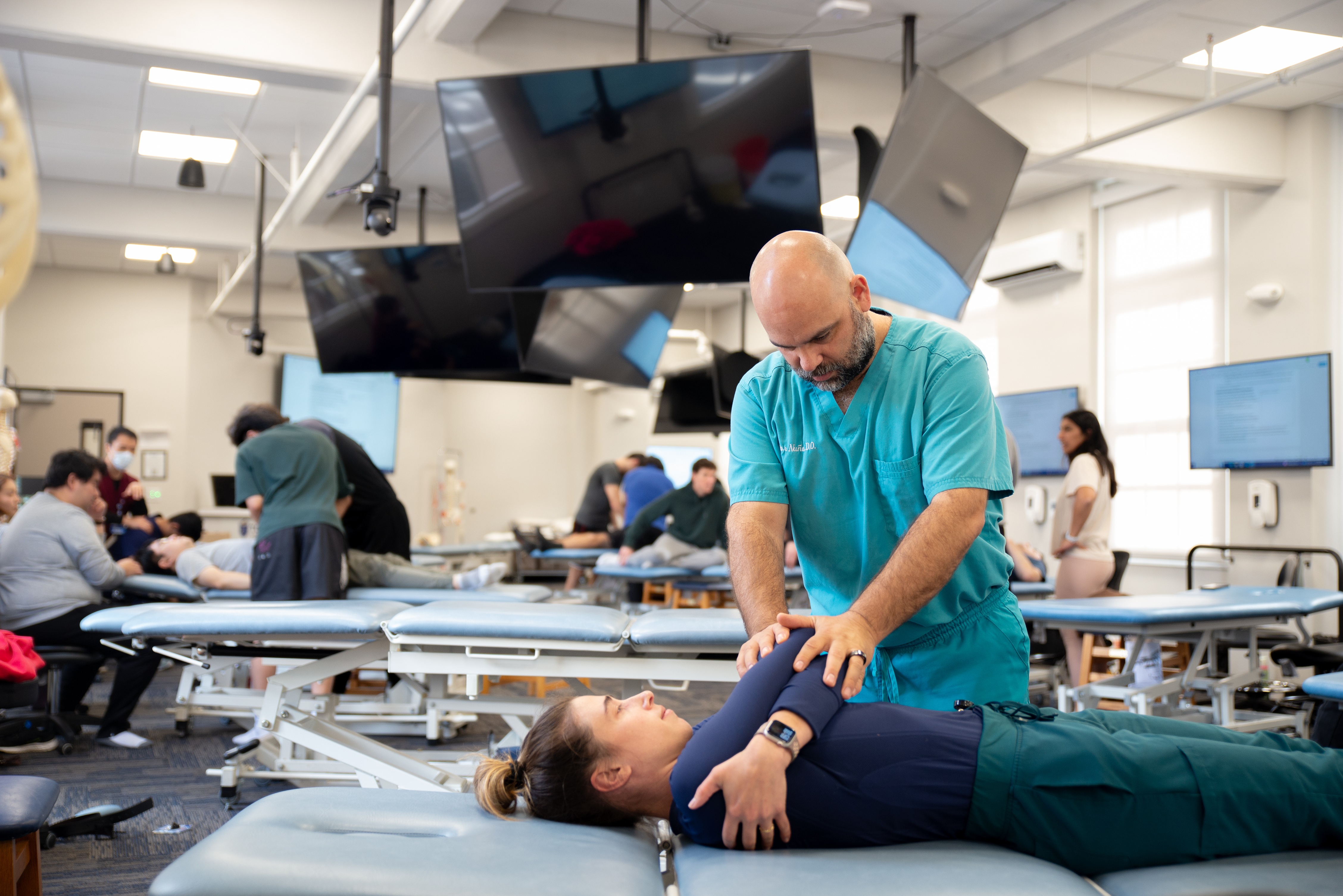 A photo shows Dr. Victor Nuño of Touro University California conducting an osteopathic manipulative medicine workshop.
