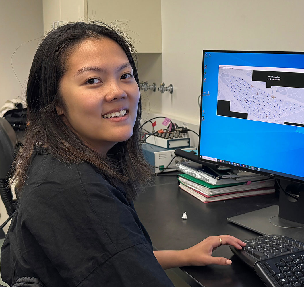 Jasmine Sun smiling while working on computer in Taylor Lab