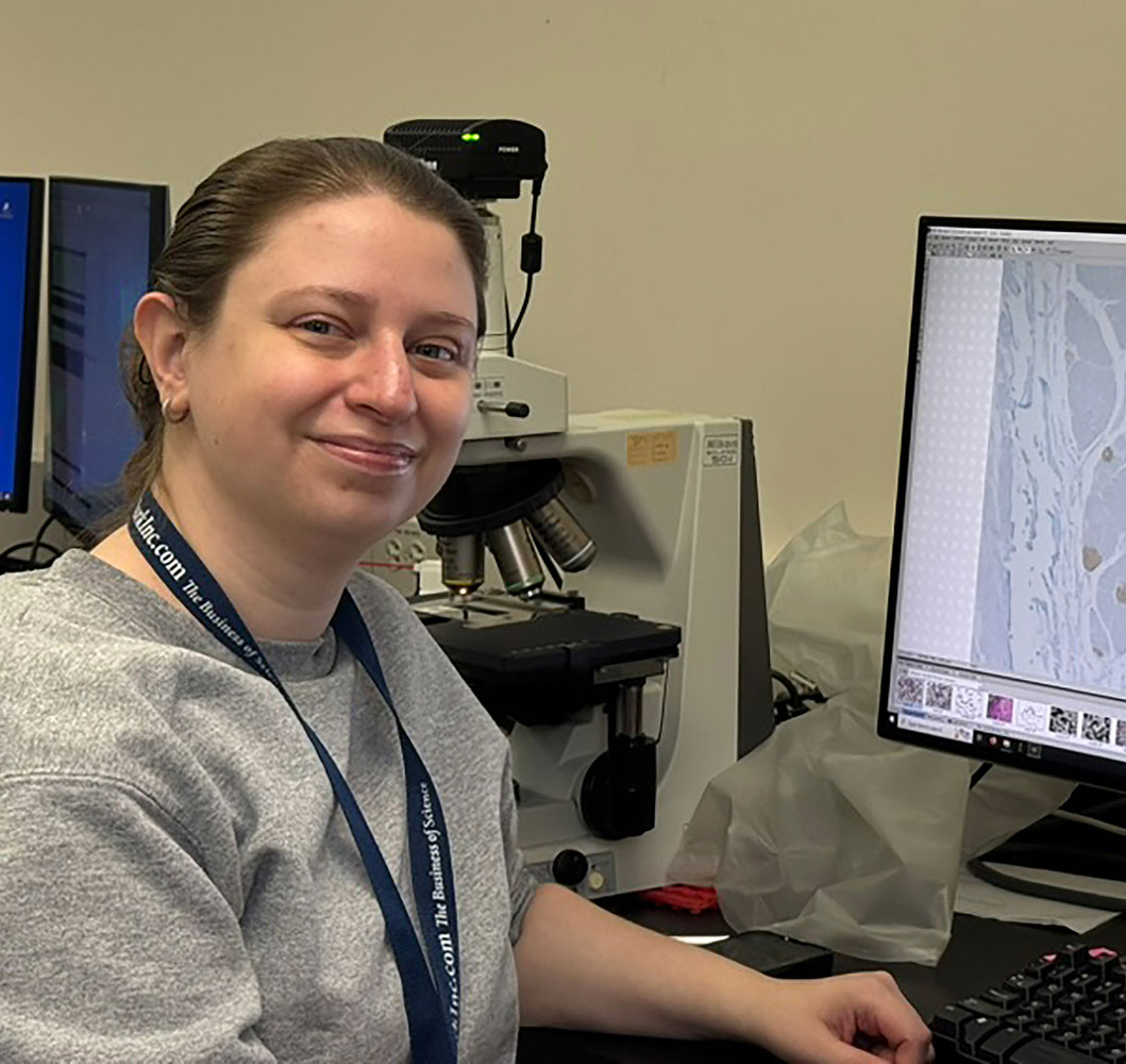 Lauren Taylor smiling while working on computer in Taylor Lab