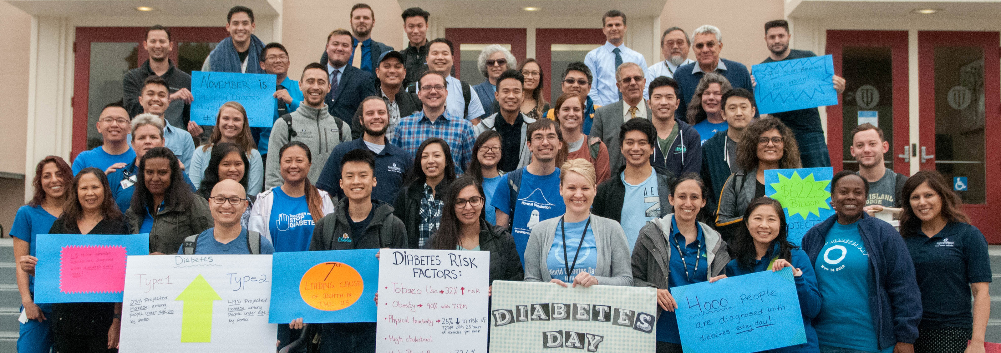 men and women standing in front of building holding signs related to diabetes