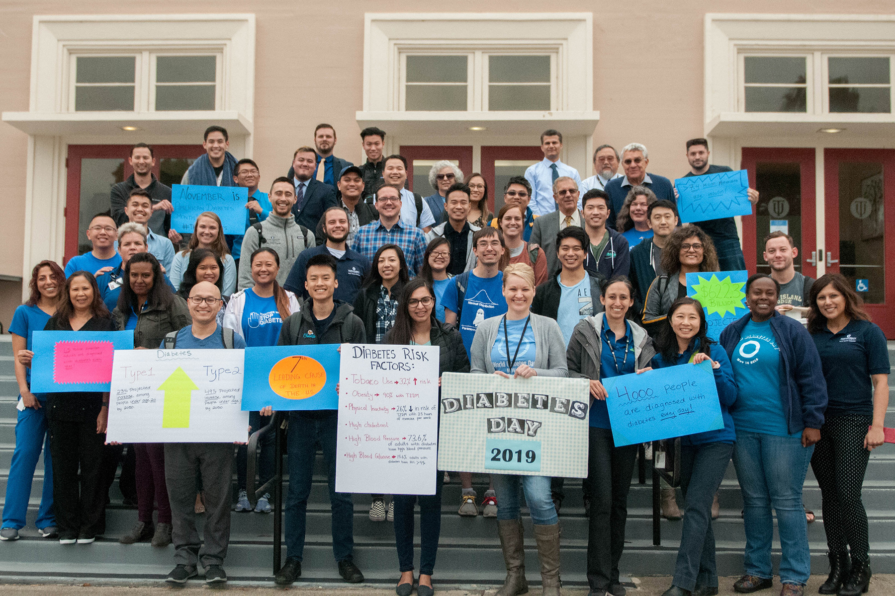 men and women standing in front of building holding signs related to diabetes