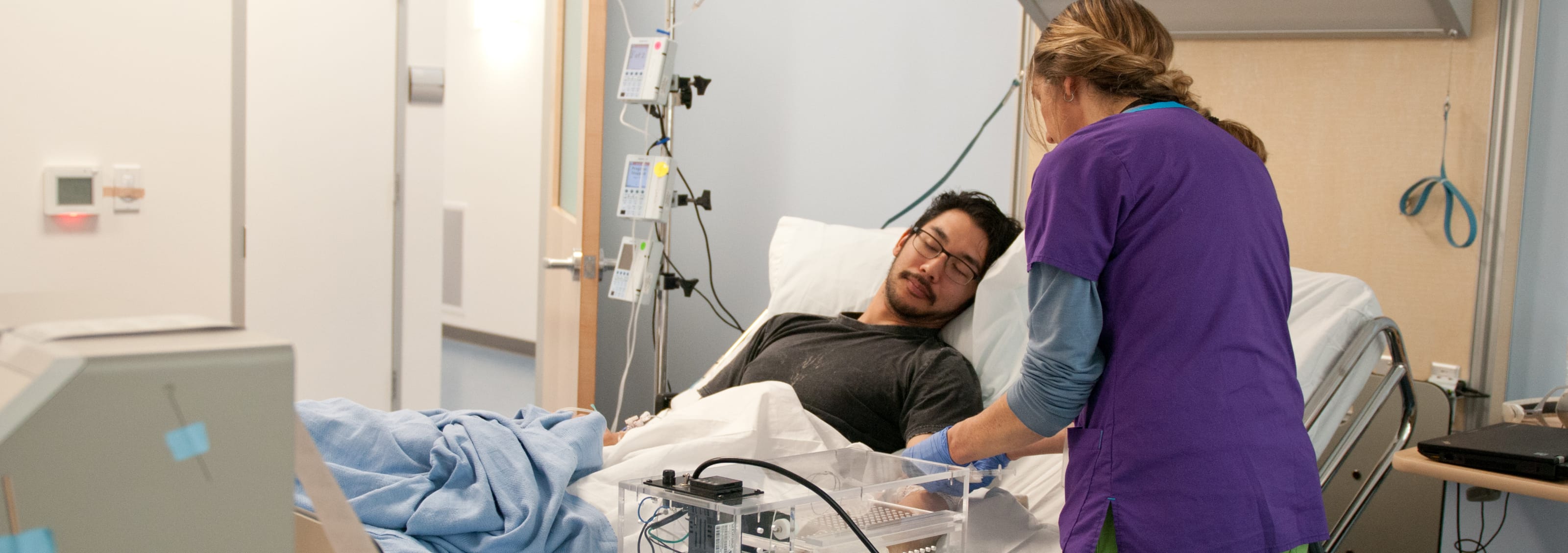 healthcare professional attending to patient in hospital bed