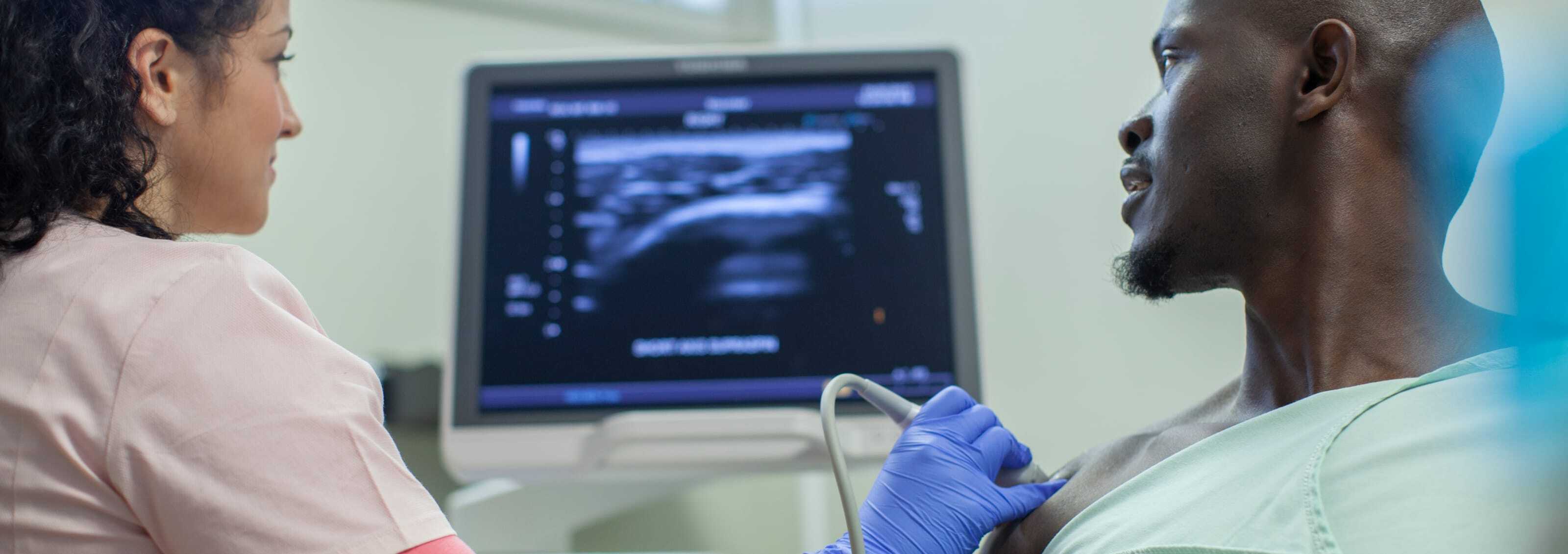 Woman taking a sonogram of a man's chest