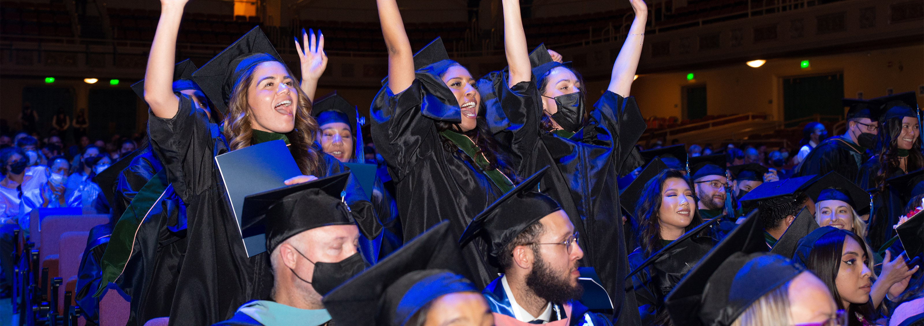 students celebrating in their seats at a graduation