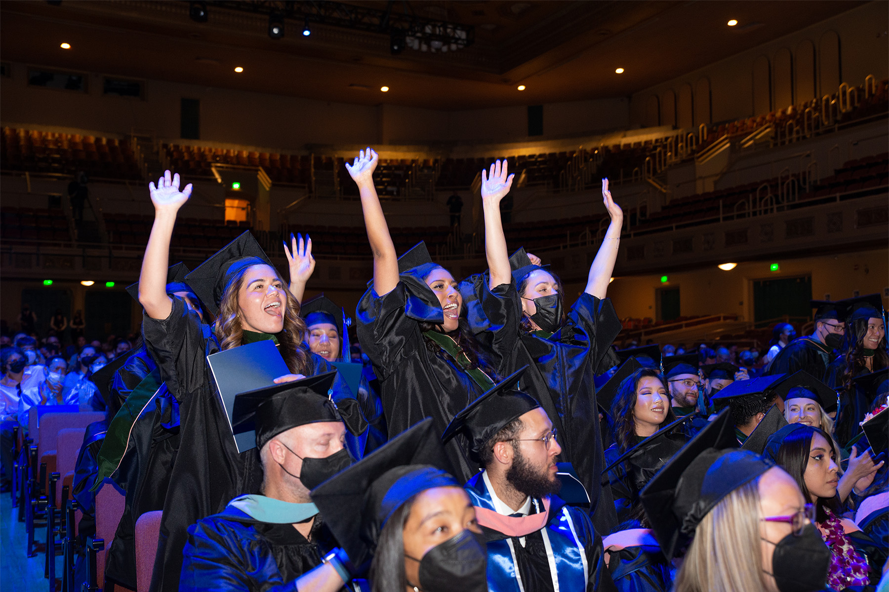 students celebrating in their seats at a graduation