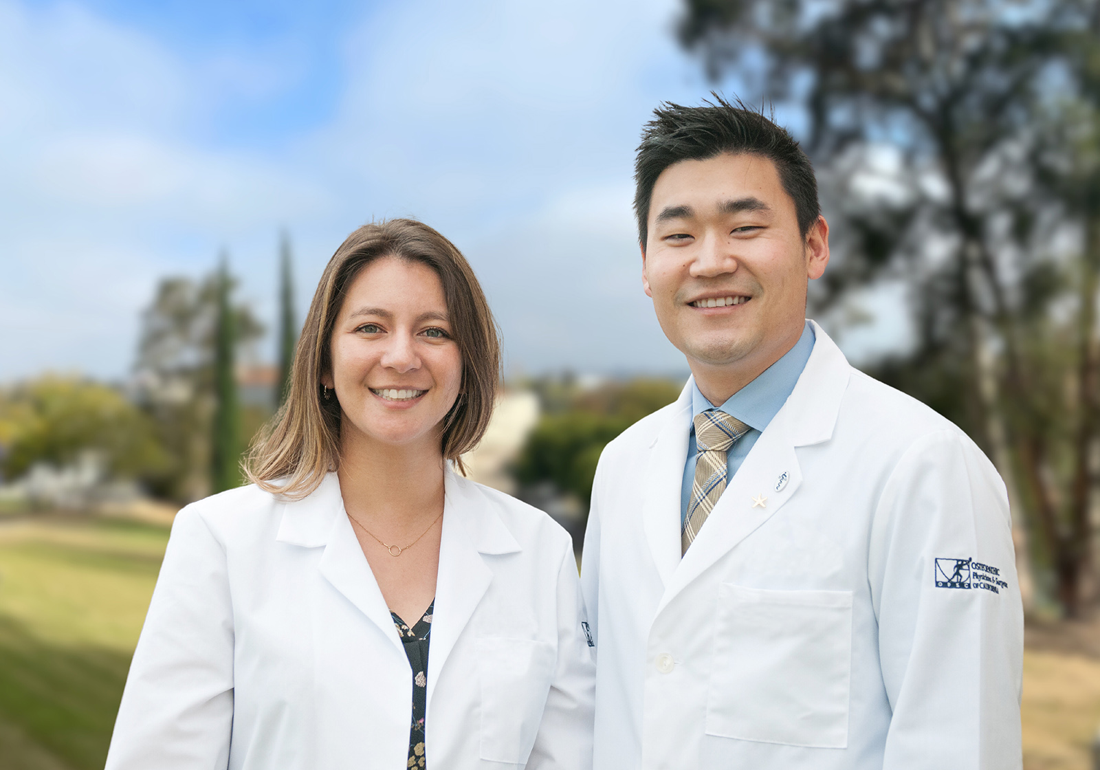 female and male COM students smiling together outdoors