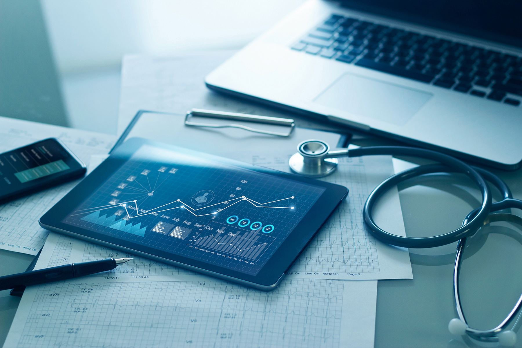 tablet, stethoscope and laptop on a desk