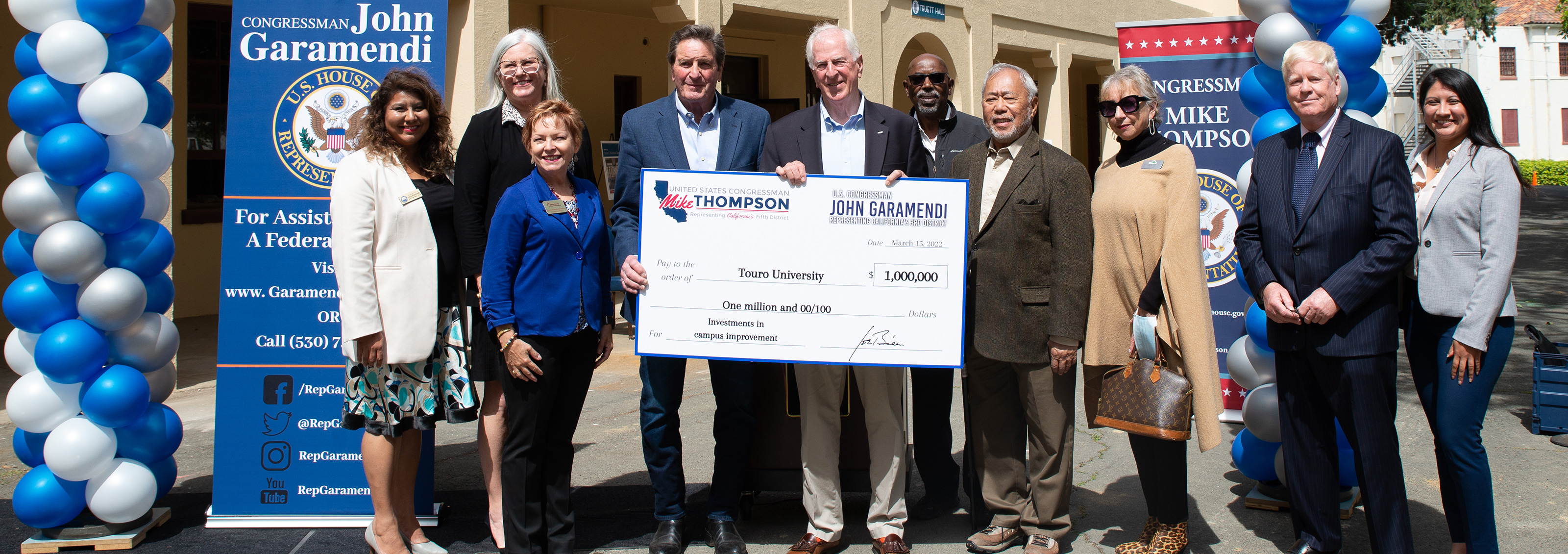 Group of men and women holding a donation check