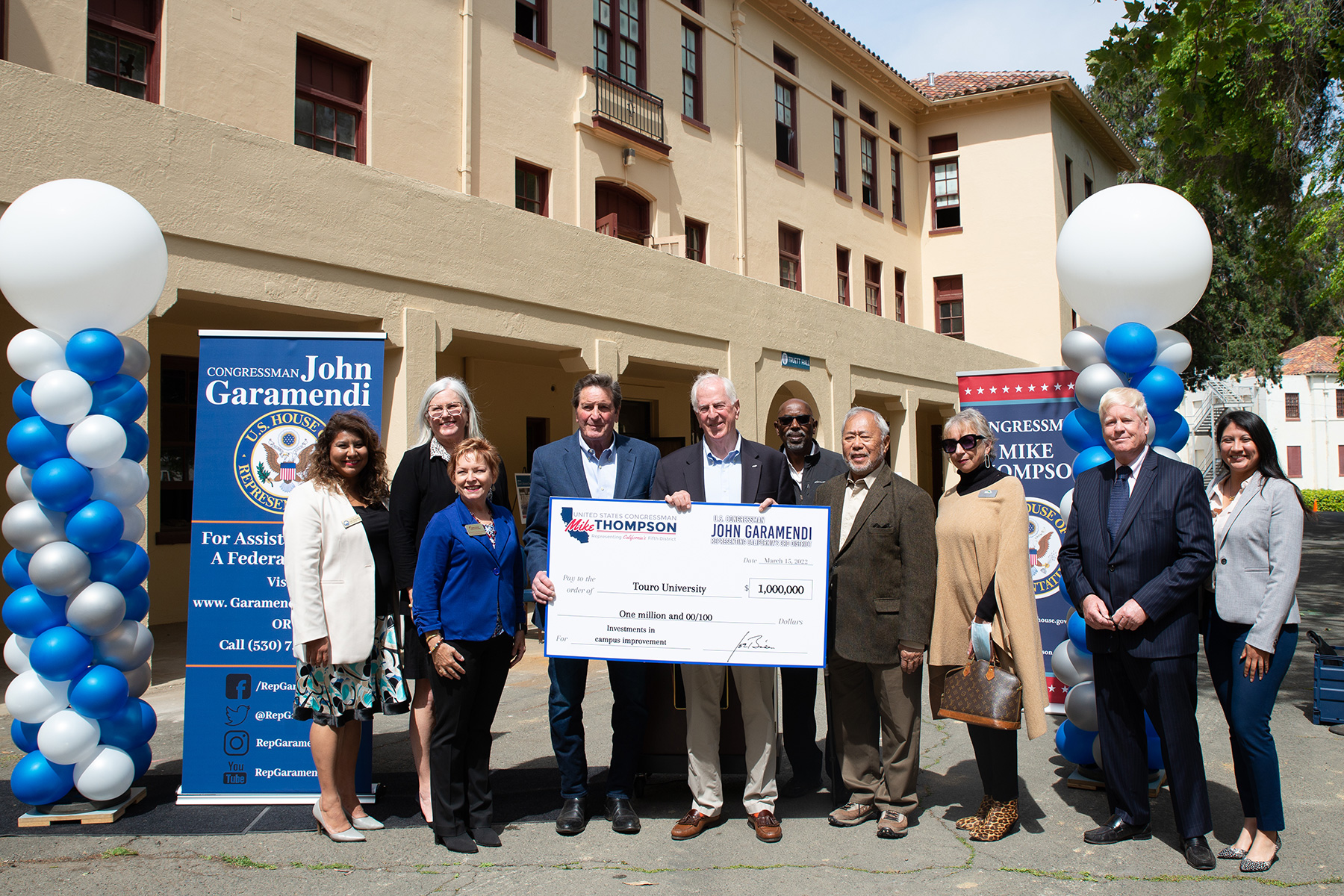 Group of men and women holding a donation check