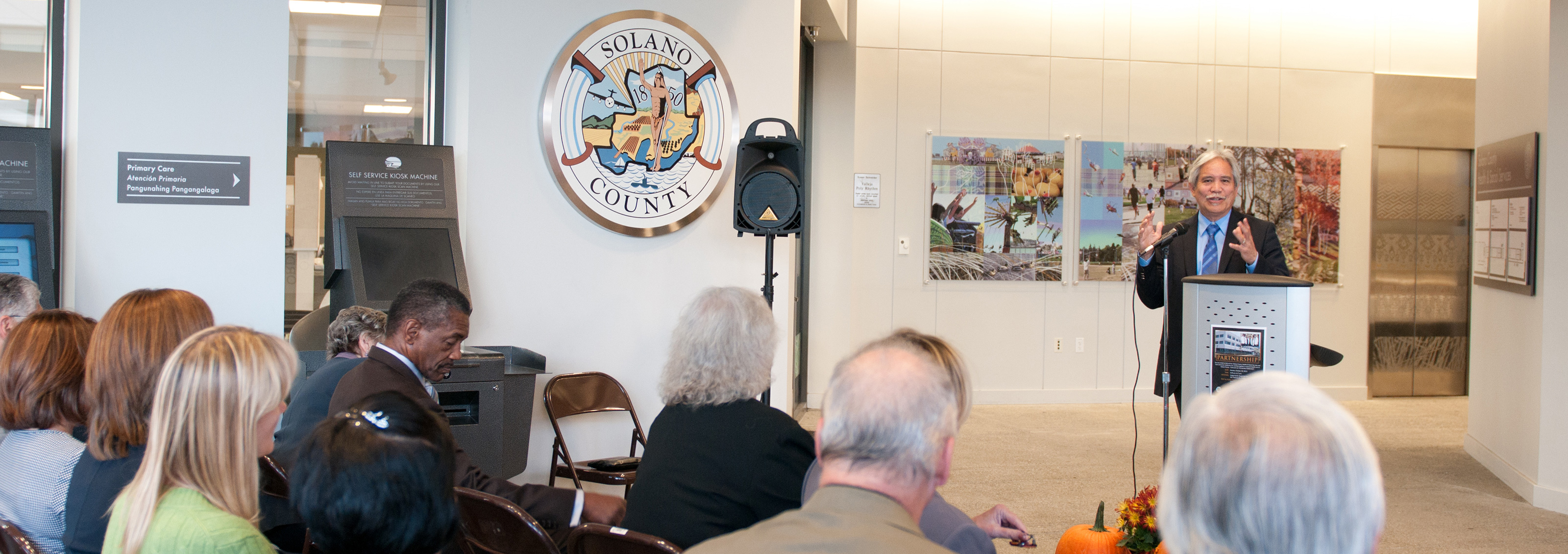 Man standing at a podium talking to a group of people