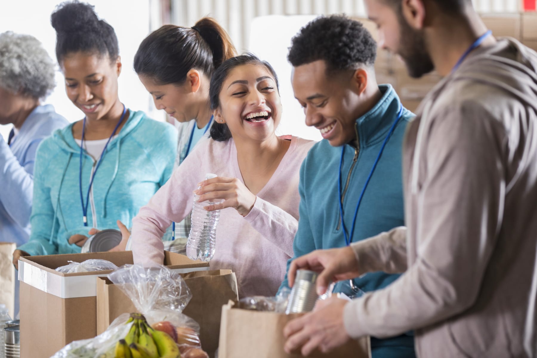 A group of people happily packing groceries