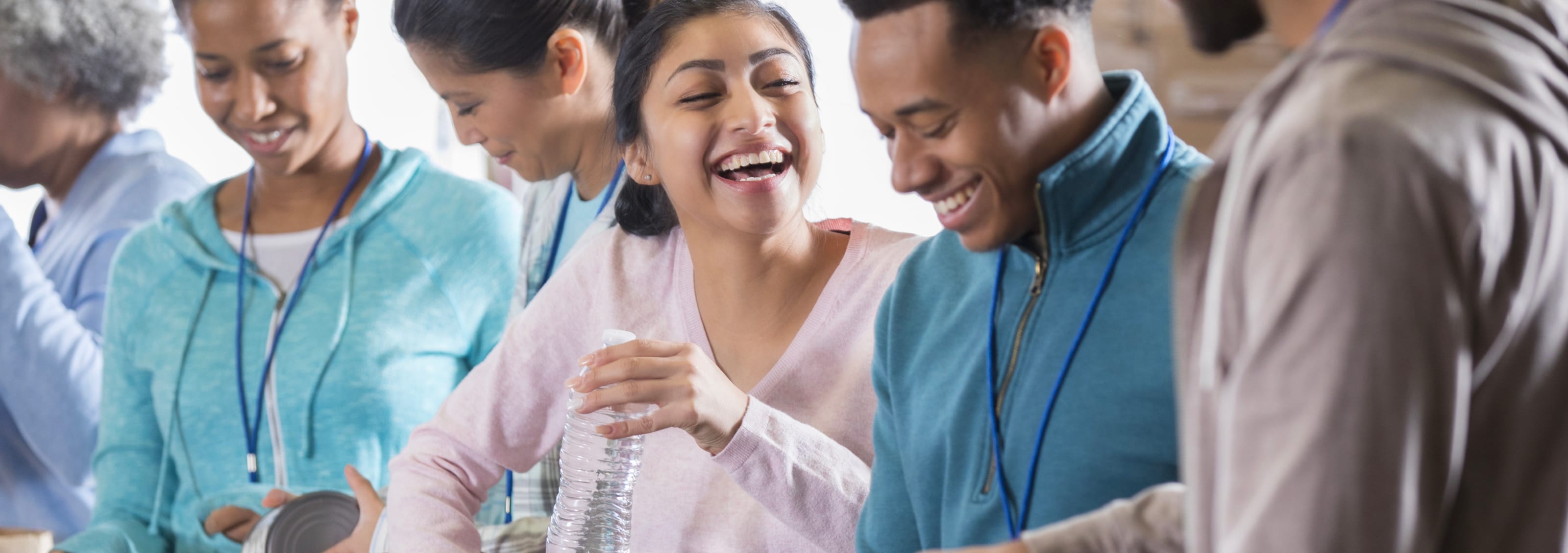A group of people happily packing groceries