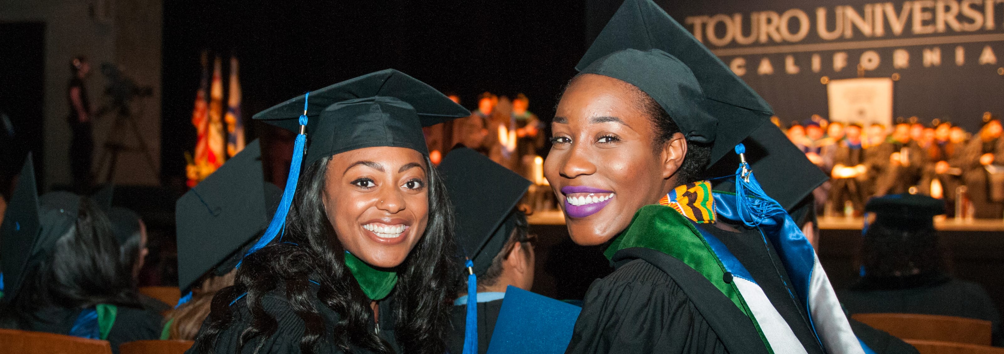 two graduating students in caps and gowns at graduation