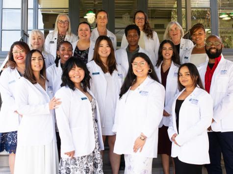A photo shows members of the MSN Class of 2026 as they pose with School of Nursing and College of Health Sciences faculty and leaders during a white coat ceremony at the Farragut Inn, Thursday, March 26, 2026.