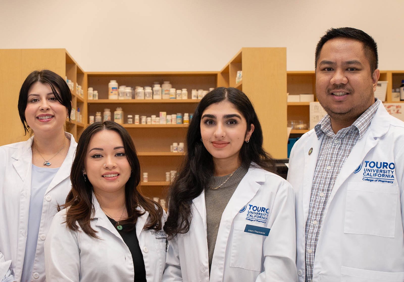 group of pharmacy students in front of pharmacy shelves