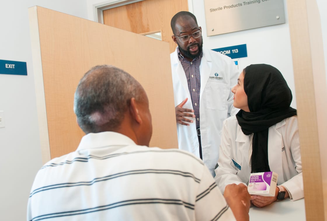 Pharmacy Student talking to Two Patients