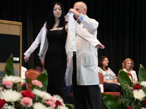 A photo shows Program Director John Ellis as he coats a Radiologic Technology student during the RadTech Class of 2027 white coat ceremony in the Lander Hall Auditorium, Monday, March 30, 2026.