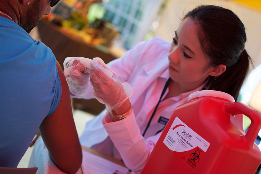 A student pharmacist gives a vaccine injection to a patient.