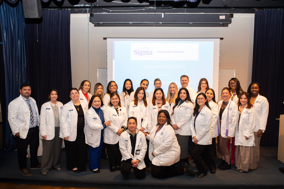 The complete group of nursing students that showcased their research posters gathered on stage in the Farragut Inn ballroom.