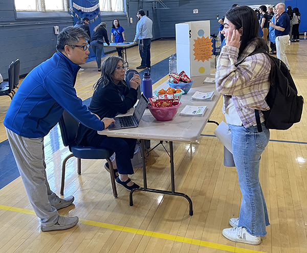 A photo shows Associate Professor Dr. Clipper Young, left, and ACDES representative Dorothy Lee, seated, as they answer a question from MSMHS student Kayla Ghodsi, right, during a World Diabetes Day event in the gym at Lander Hall on the campus of Touro University California, Wednesday, Nov. 8, 2023.