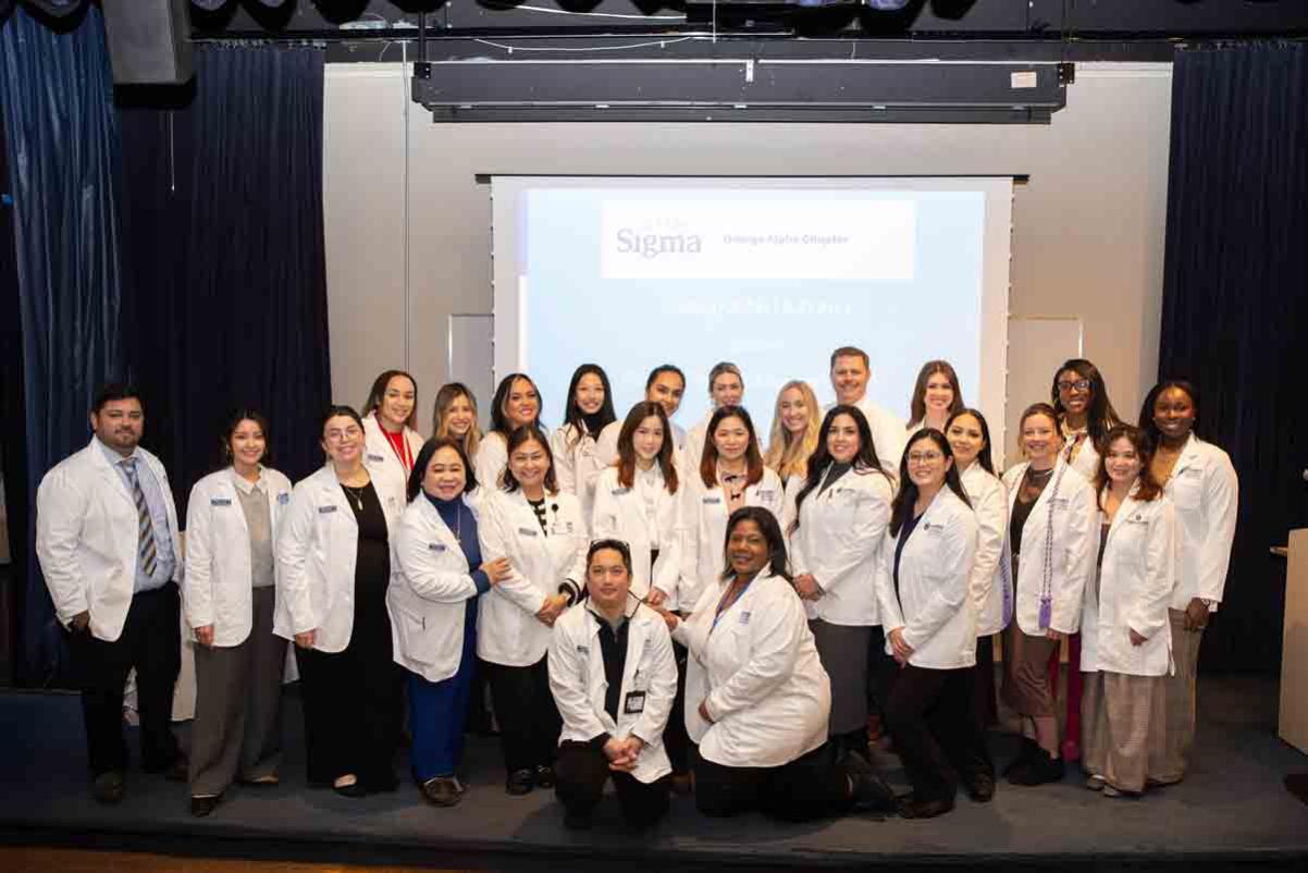 The complete group of nursing students that showcased their research posters gathered on stage in the Farragut Inn ballroom.