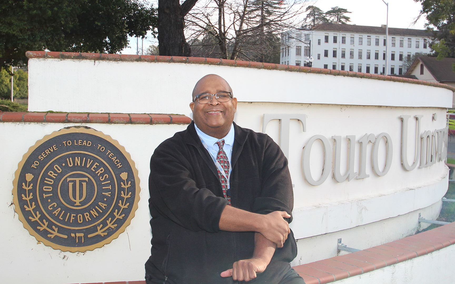 A photo shows Dr. Mark Gaines, Associate Director for Diversity, Inclusion, and Belonging at Touro University California. Gaines says TUC alumni can serve as role models for current students, who can see successful alumni who “look like them.”