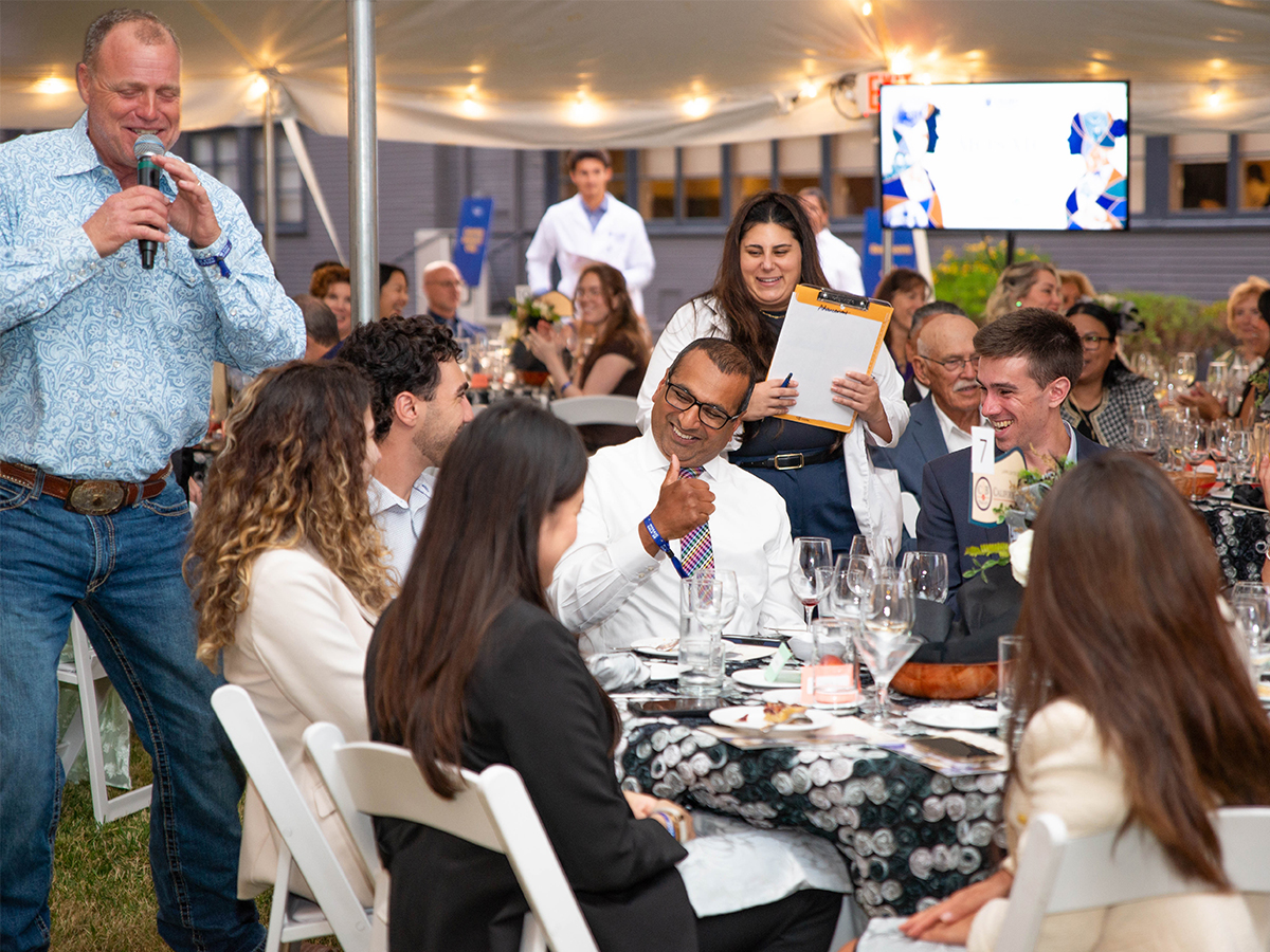 A photo shows auctioneer Vince Morrow, left, as he works a table during the live auction at the 10th Annual Mosaic Gala, Aug. 27, 2026.