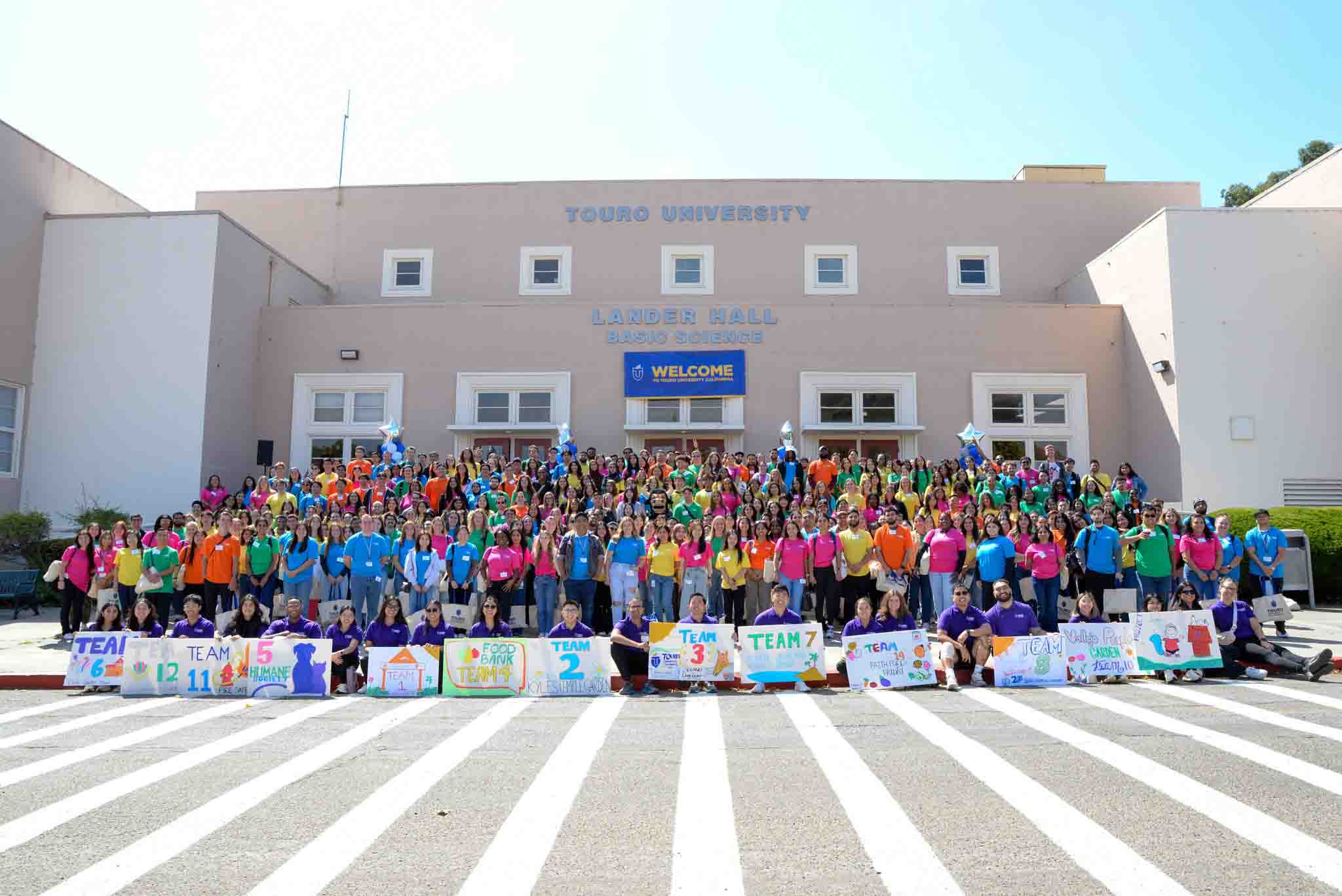 Students pose in a large group during orientation at Touro University California in front of Lander Hall.
