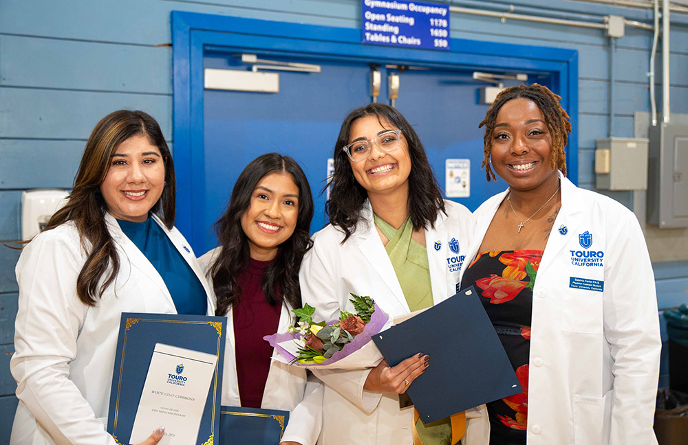 Four PA students pose together and smile for the camera