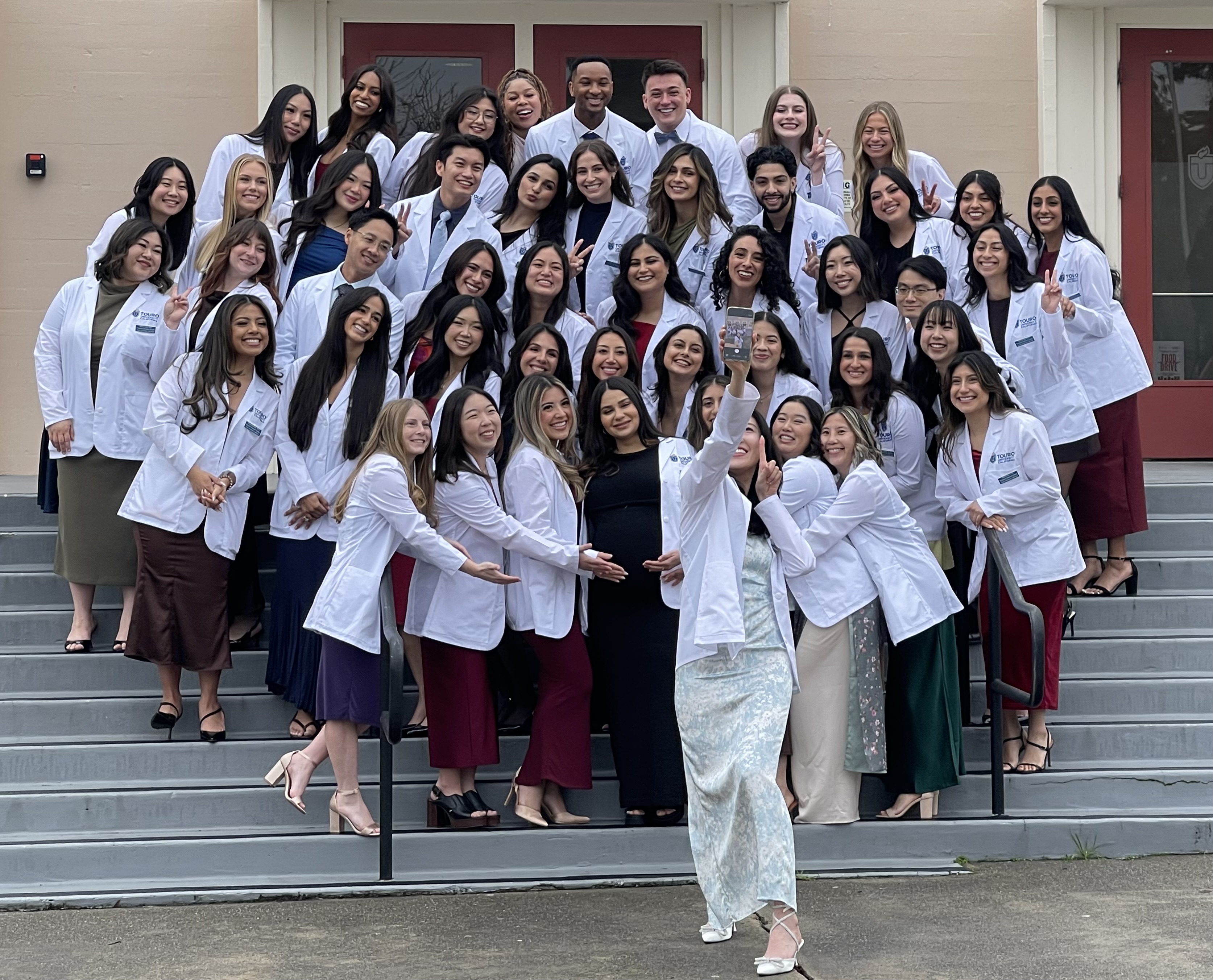 Students on the Joint PA/MPH Program\'s Class of 2027 pose for a selfie on the steps at Lander Hall prior to their White Coat ceremony, Friday, Jan. 23, 2026.