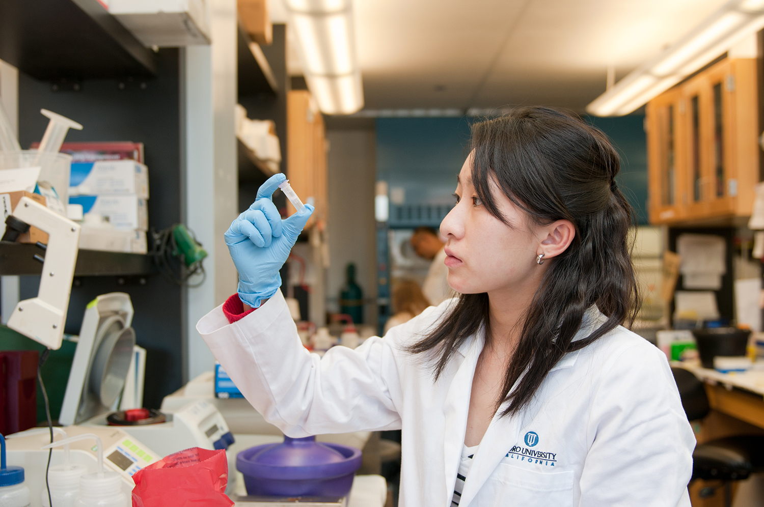 TUC Pharmacy student looks at test tube in lab